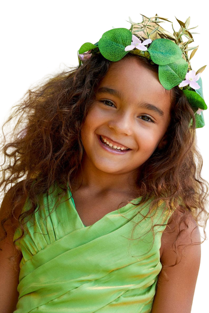 Young girl wearing a green dress and leafy headband with flowers on a white background