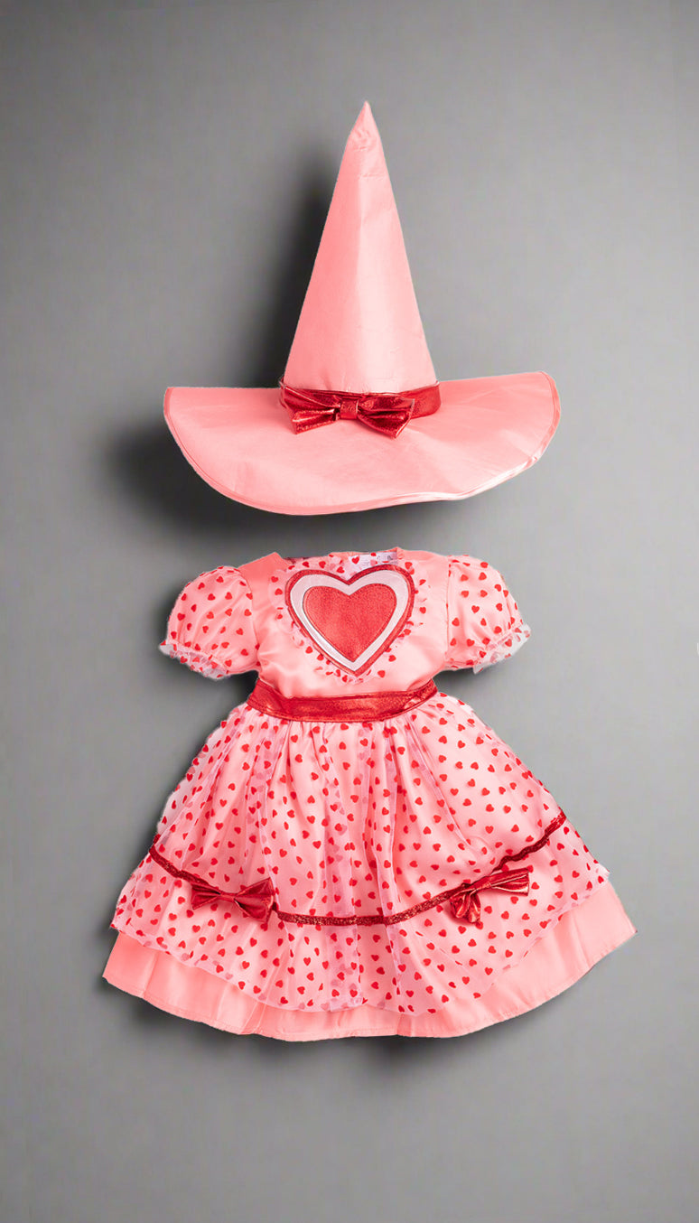 Pink dress with red heart and matching witch hat on a gray background