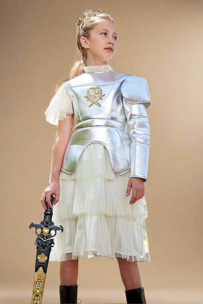 Child girl in silver armor and white dress holding a sword on a white background